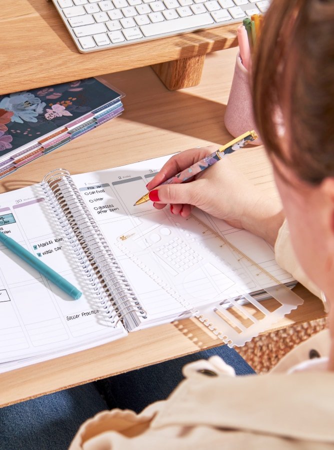 person writing inside of coiled lifeplanner.